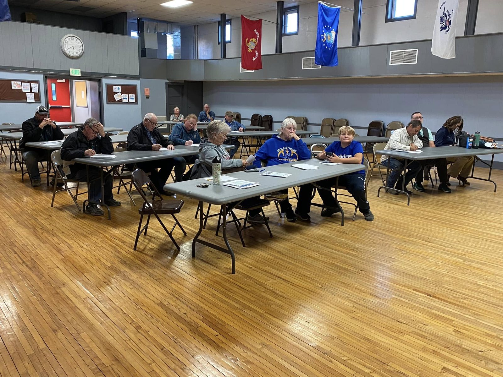 Residents seated at tables inside the Dodge Auditorium during a community event