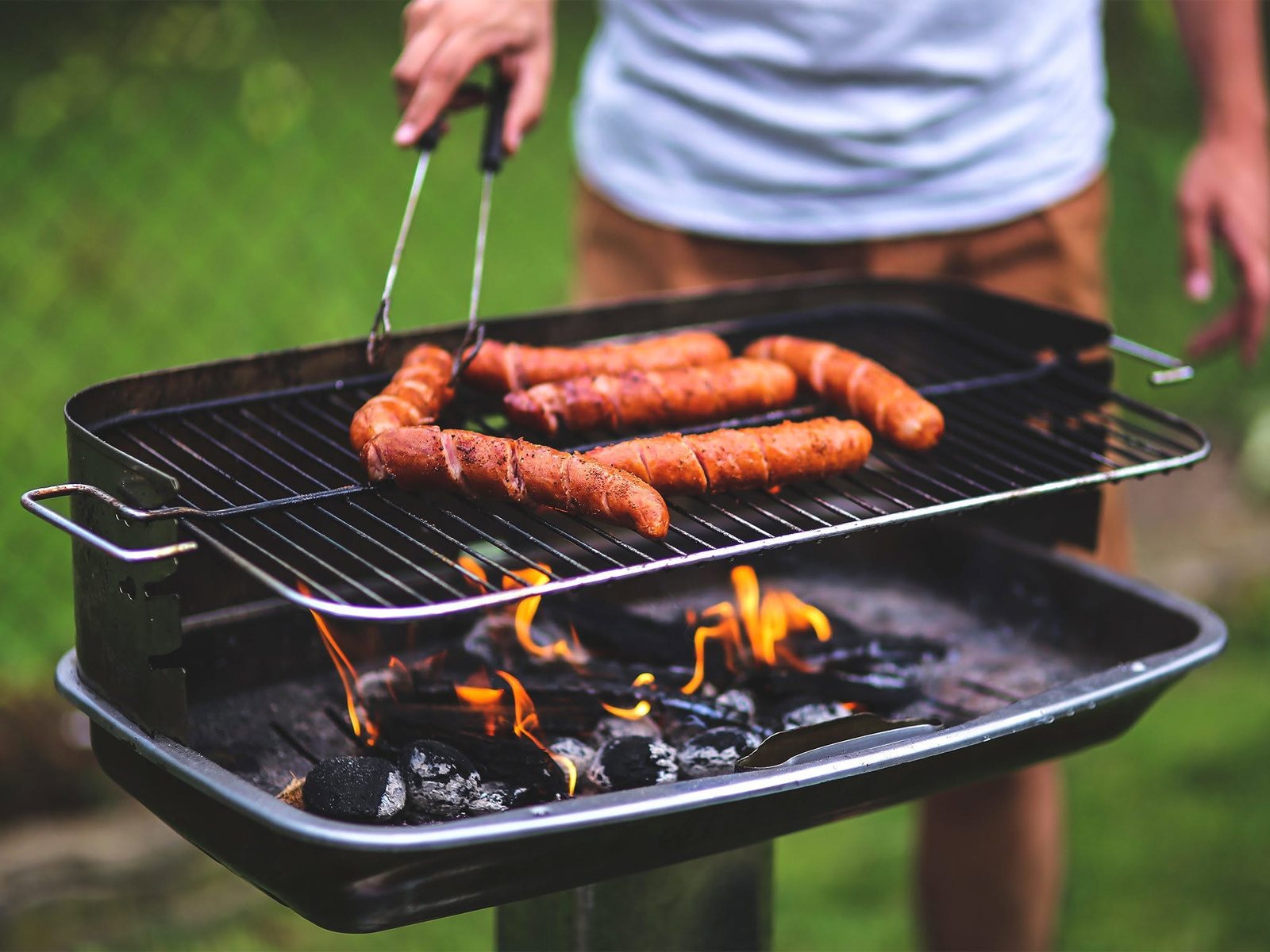 Sausages cooking on a charcoal grill at a Dodge community gathering