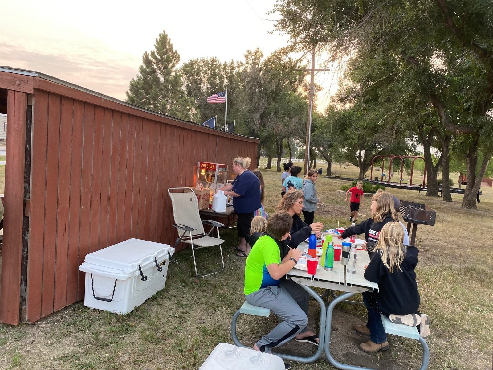 Neighbors visiting at an evening gathering in the Dodge park