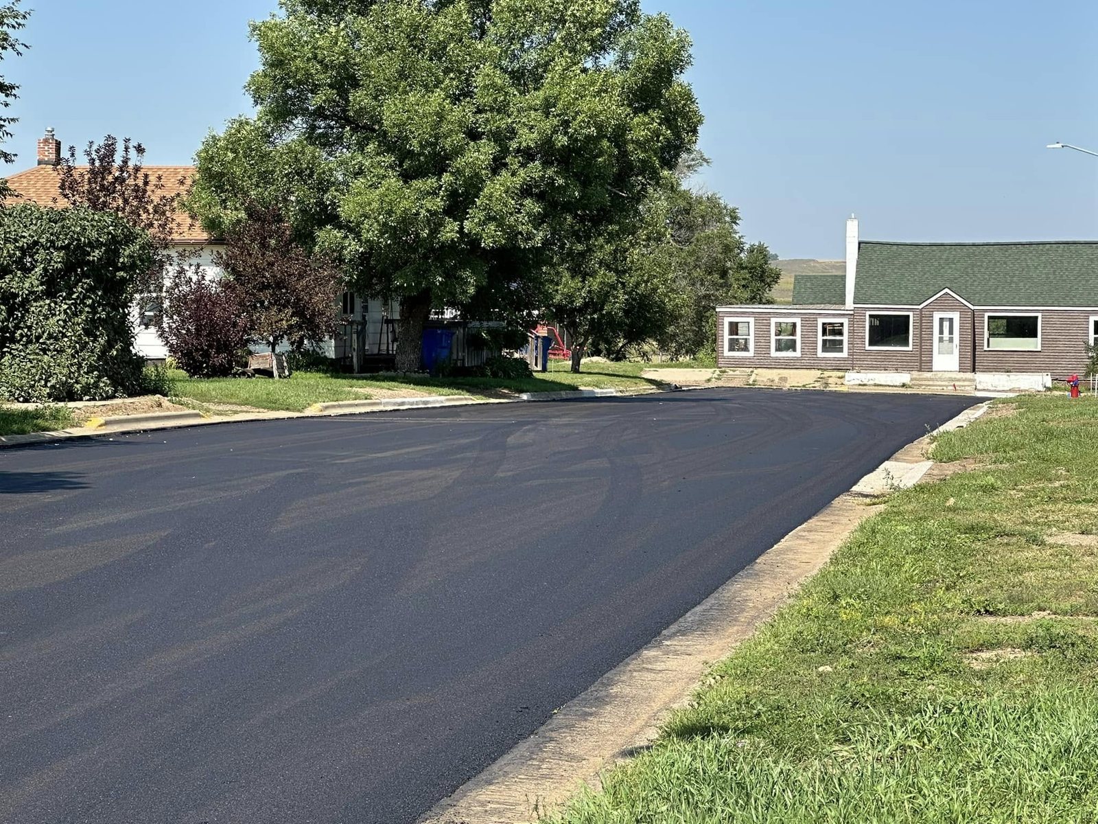 A freshly paved residential street in Dodge lined with trees